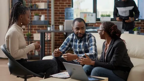Business colleagues planning on a laptop in an office — how to start an online business in Nigeria
