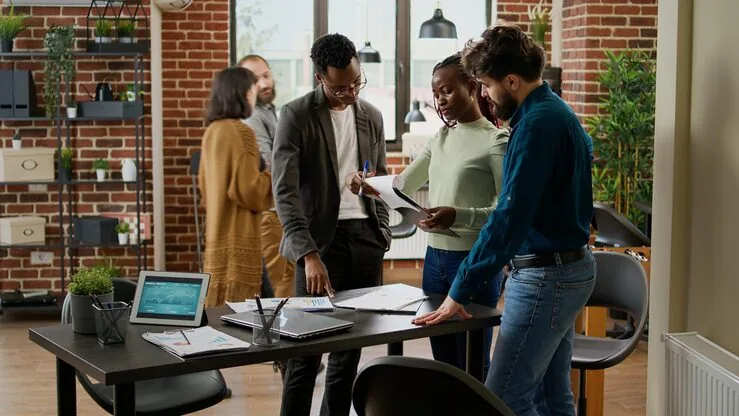 Business colleagues planning over documents in an office — how to use customer data to increase sales