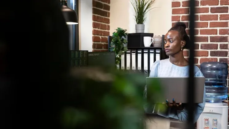 A businesswoman working on a laptop in an office — how to use technology to compete with larger companies