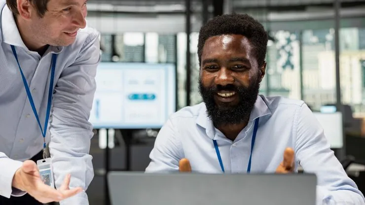 Business colleagues reviewing on a laptop in an office — how to use technology to improve customer experience