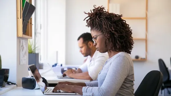 Business colleagues working in an office — an article about in-house developers vs software agency