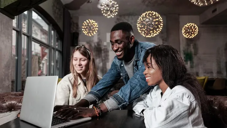 Business colleagues working on a laptop in an office — an article about marketplace app development Nigeria