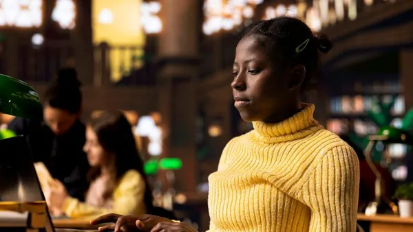 African business colleagues taking notes in a library — an article about parent communication apps for Nigerian schools