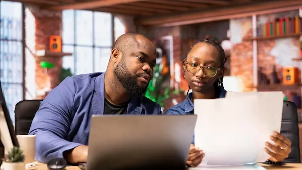 Business colleagues working on a laptop in an office — an article about product SEO Nigeria