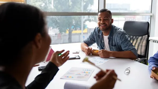 Business colleagues working in an office — an article about signs your business needs a mobile app