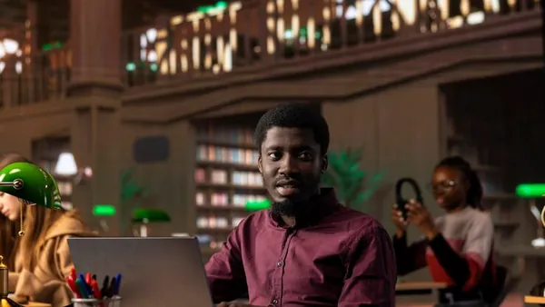 An African businessman working in a library — an article about student management software in Nigeria