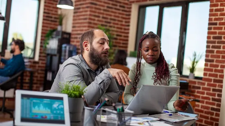 Business colleagues reviewing over documents in an office — an article about technology solutions for Nigerian marketing