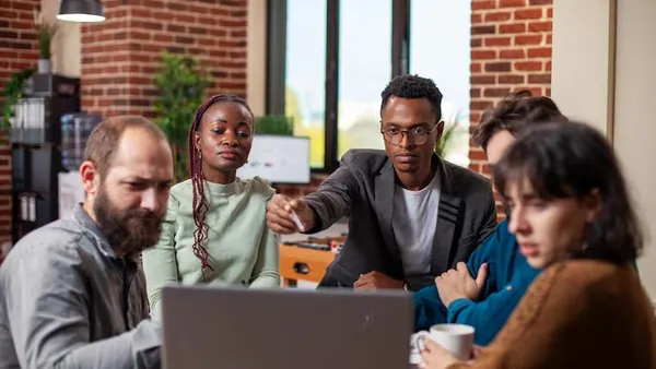 Business colleagues in a meeting in an office — an article about technology solutions for Nigerian travel agencies