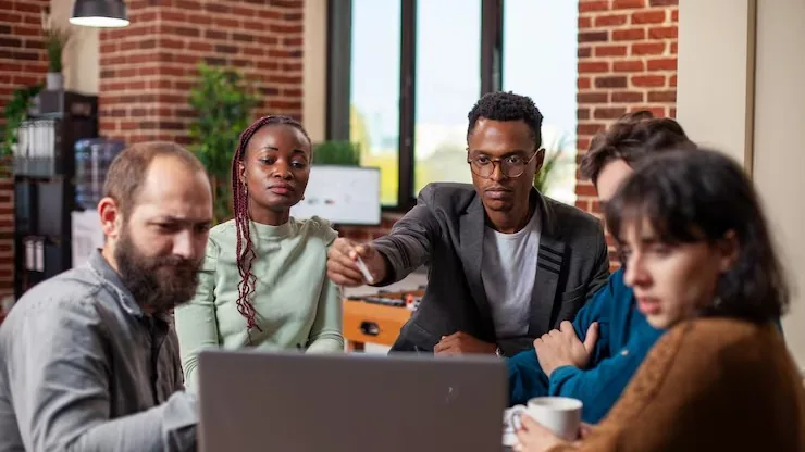 Business colleagues in a meeting in an office — an article about technology solutions for Nigerian travel agencies