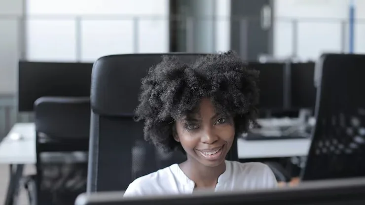 An African businesswoman working at a computer in an office — an article about website business ideas for Nigeria