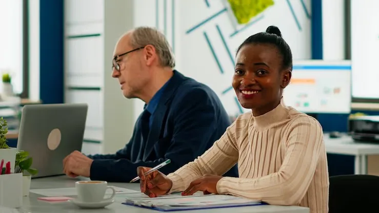 An African businesswoman in a meeting over documents in an office — an article about website design for Nigerian consultants