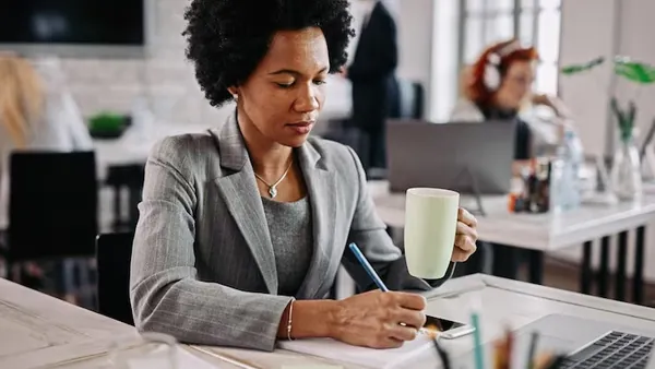 African business colleagues taking notes over documents in a cafe — an article about website design for Nigerian dentists