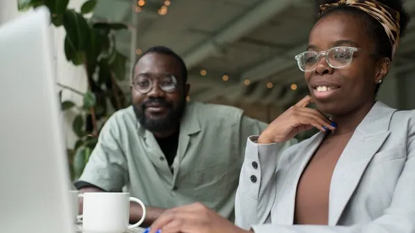 Business colleagues working on a laptop in an office — an article about website development Ibadan