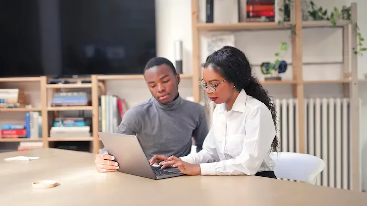 Business colleagues working at a computer in an office — an article about website development for beauty businesses in