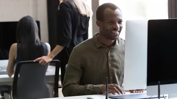 An African businessman working at a computer in an office — an article about website development for Nigerian professionals