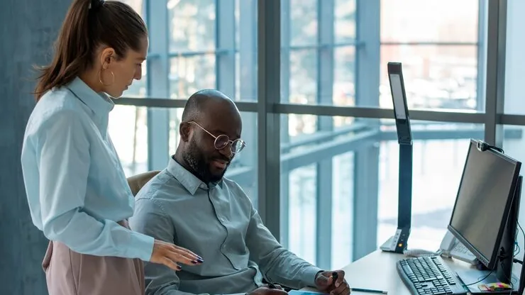Business colleagues working in an office — an article about website maintenance cost in Nigeria
