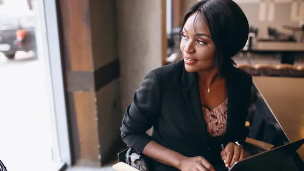 An African businesswoman working at a computer in an office — an article about website vs Google Business Profile