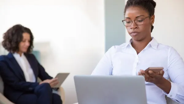 A businesswoman working in an office — an article about website vs social media for business
