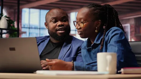 Business colleagues working on a laptop in an office — an article about website vs software for business