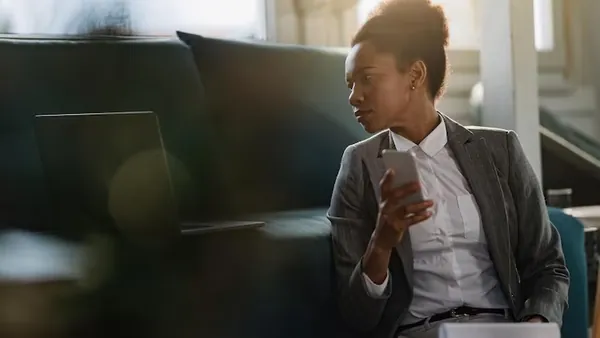 An African businesswoman reviewing on a laptop at home — an article about ROI of a mobile app