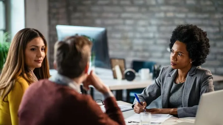 African business colleagues in a meeting over documents in an office — an article about software development contract
