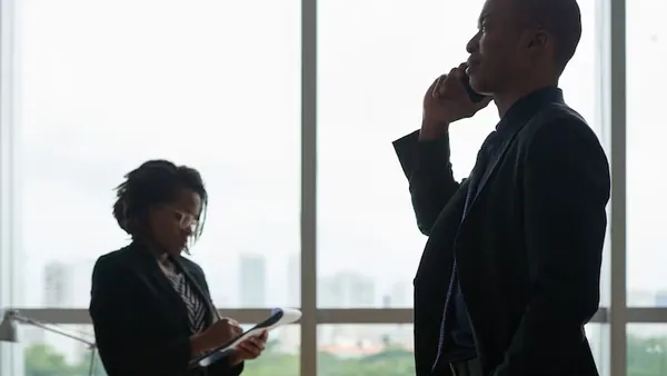 Business colleagues taking notes on a phone in an office — when should a business build a mobile app
