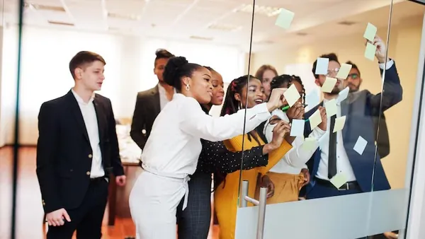 Business colleagues taking notes in an office — why Nigerian businesses need a CRM